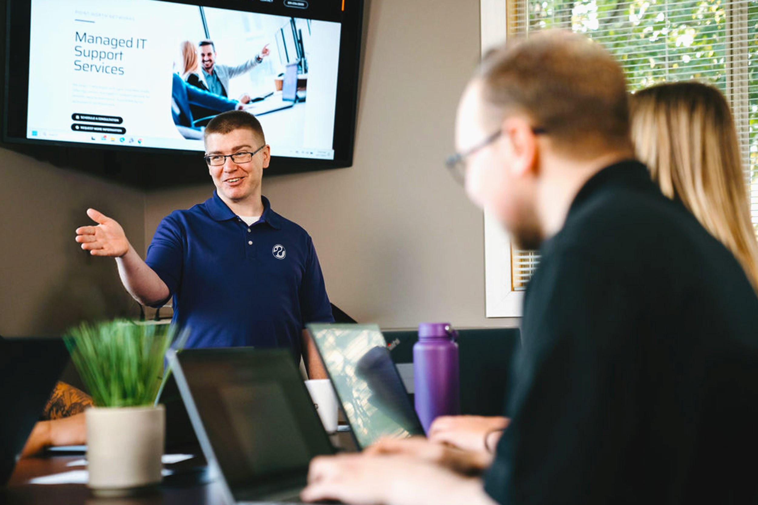 man speaking to group of people in an office space